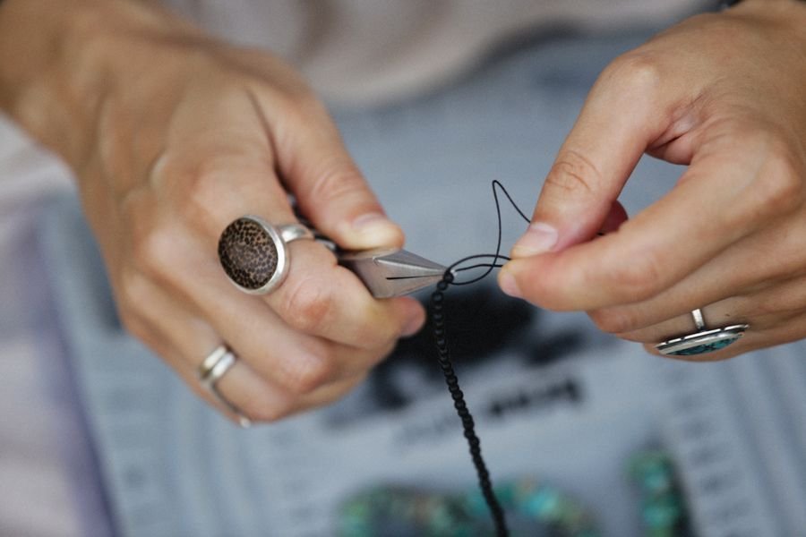 Hands finishing a beaded loom piece